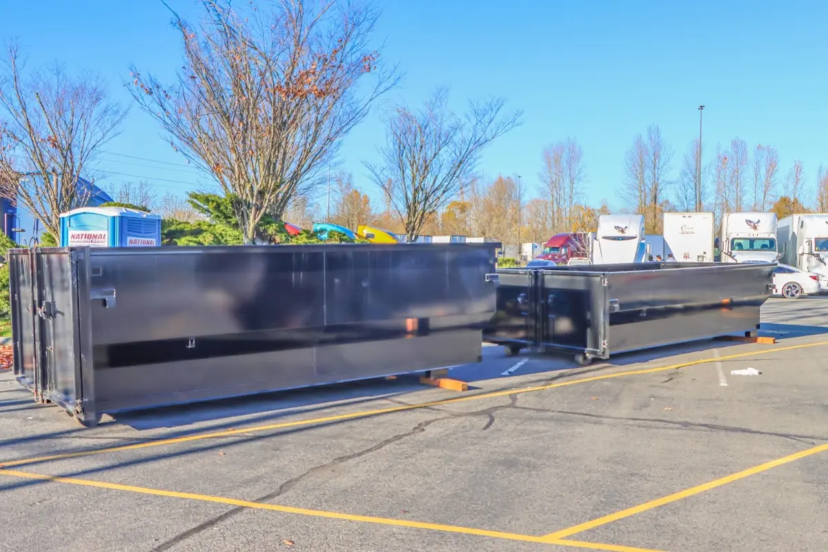 Professional dumpster rental service with roll-off container on residential driveway in Mead